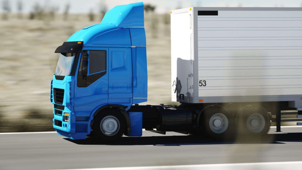 Side profile of a commercial truck and trailer traveling on a highway