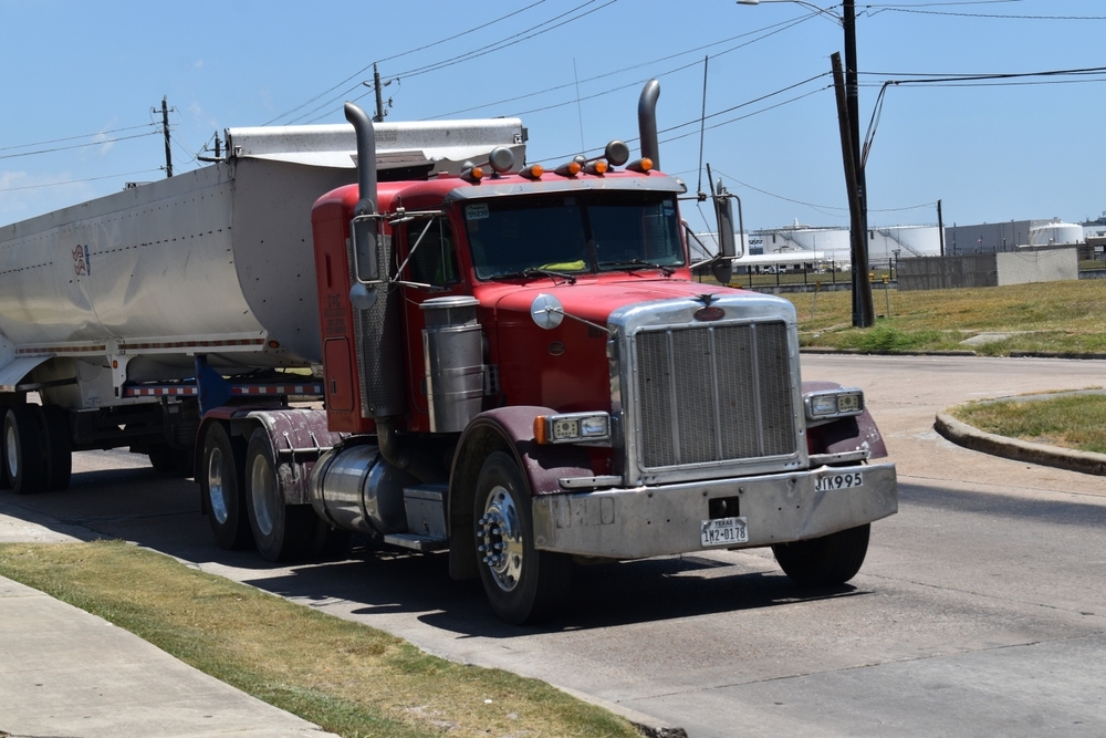 Red semi-truck hauling a trailer on a Texas road